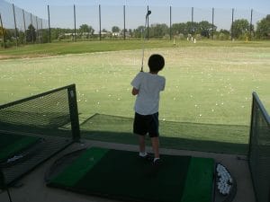 camper at driving range at golf summer day camp